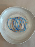 Beaded bracelet set on a textured ceramic plate 