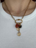 Gold chain necklace with charms on a white background