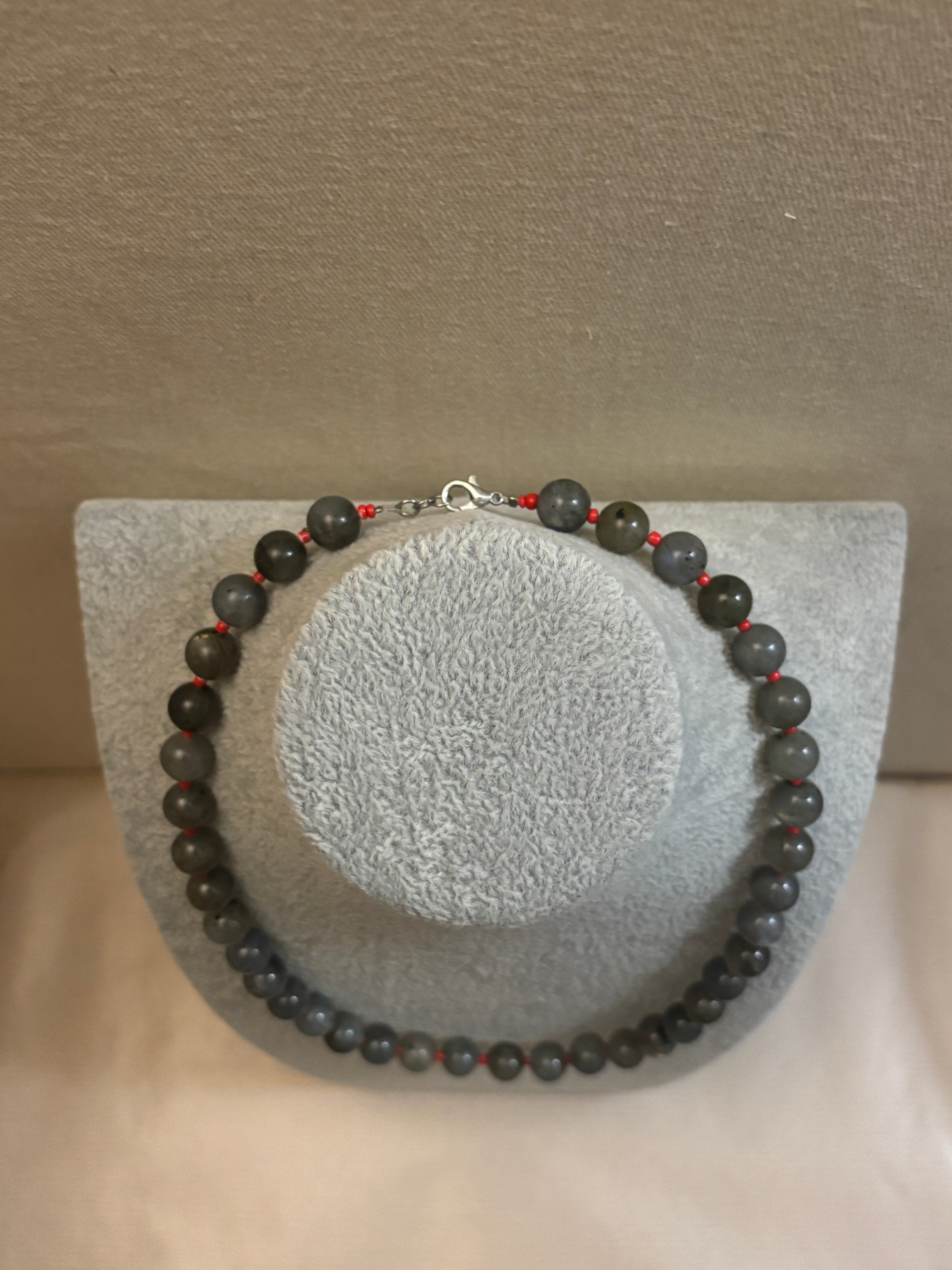 Beaded bracelet on a gray stand with a neutral background