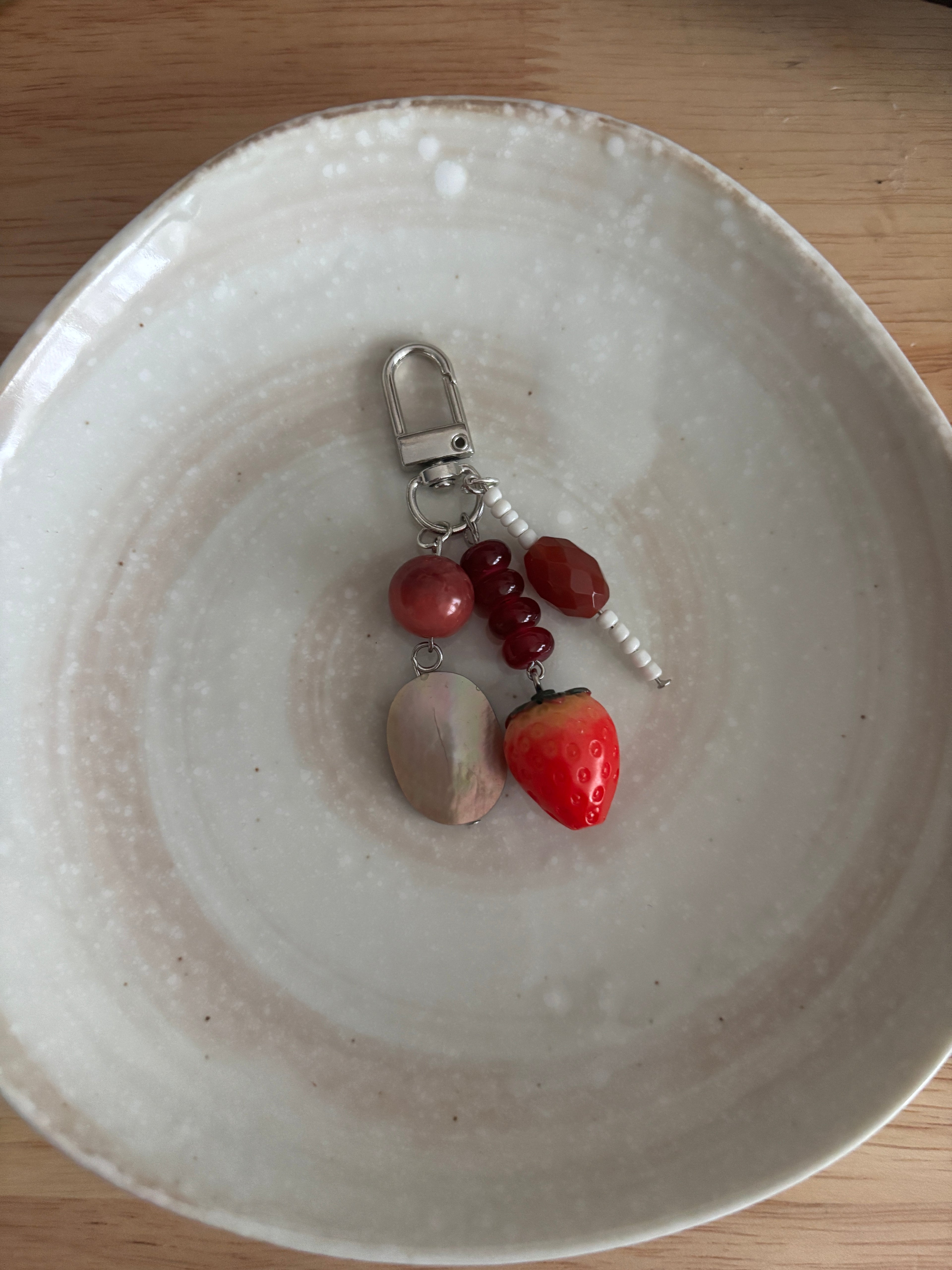 Keychain with fruit-shaped charms on a white ceramic plate