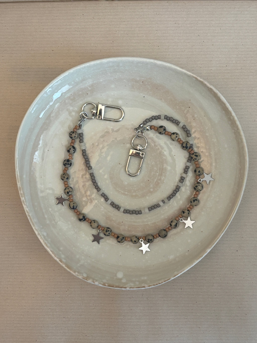 Necklace with star charms on a ceramic plate