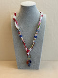 Multicolored beaded bracelet on a gray mannequin bust against a beige background