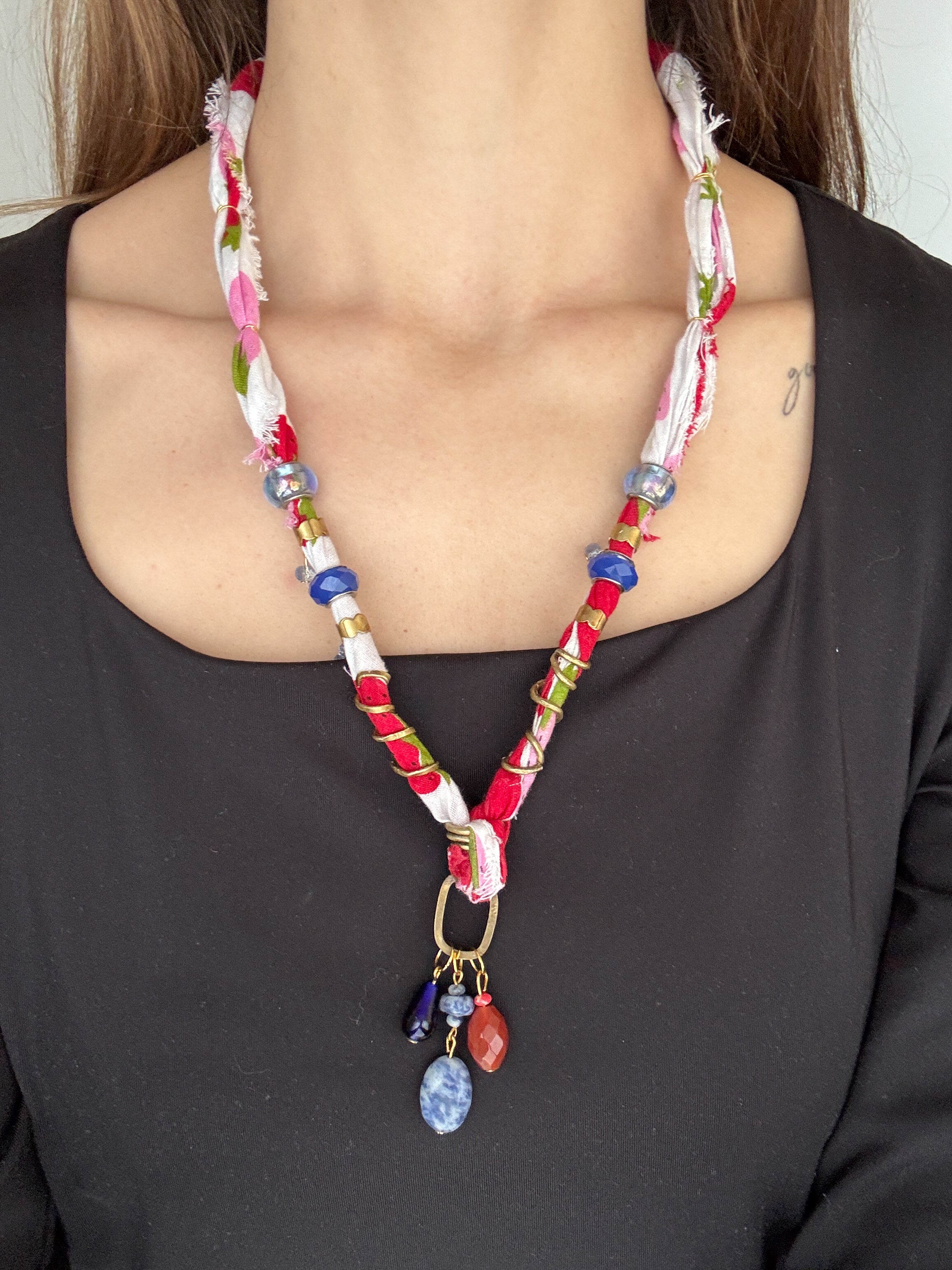 Colorful beaded necklace with charms on a plain background