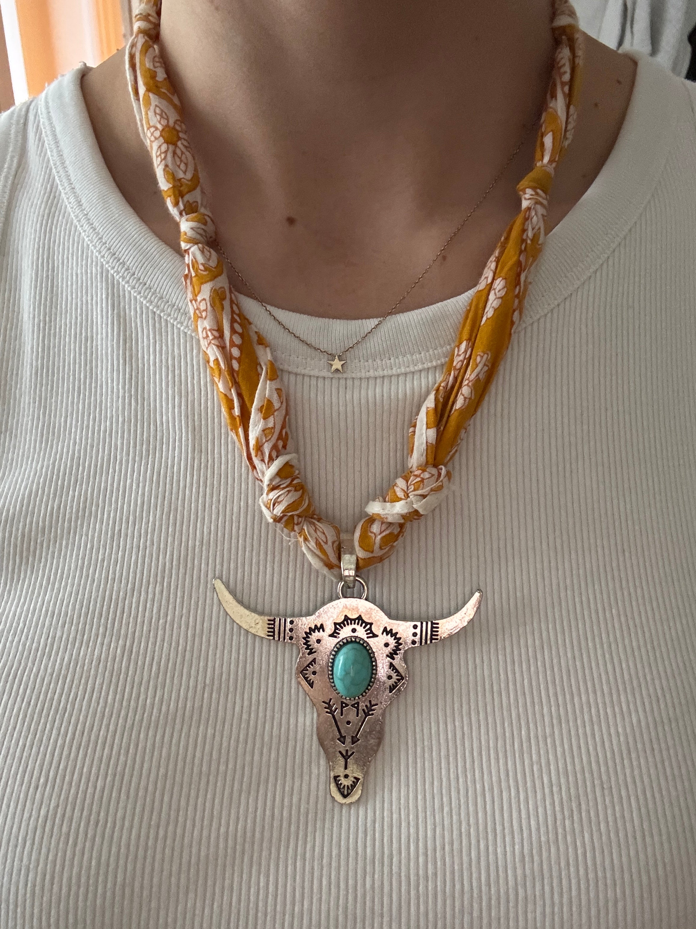 Decorative necklace with a large, ornate pendant on a textured surface