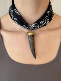 Necklace with a large, decorative pendant worn by a person.