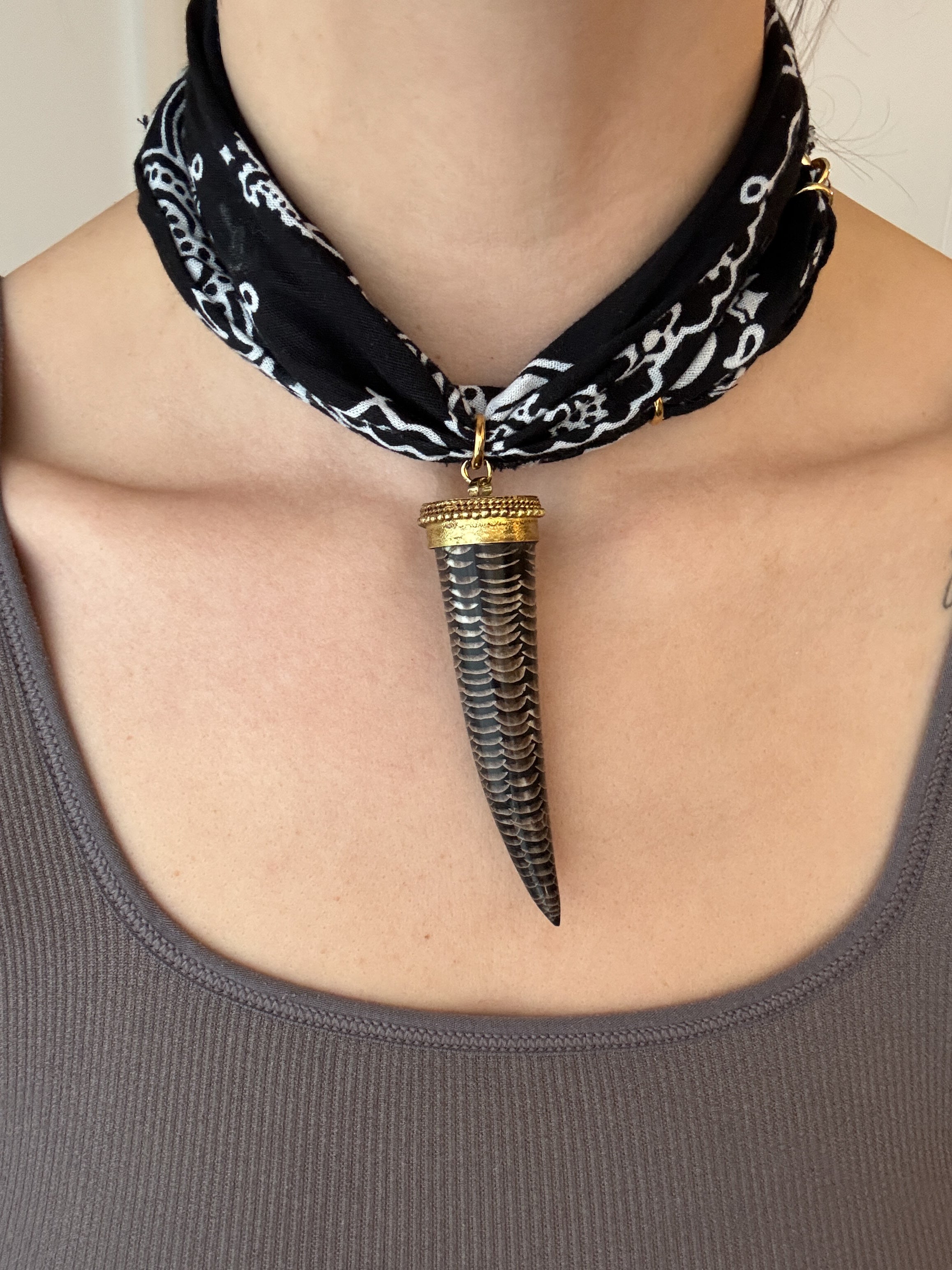 Necklace with a large, decorative pendant worn by a person.