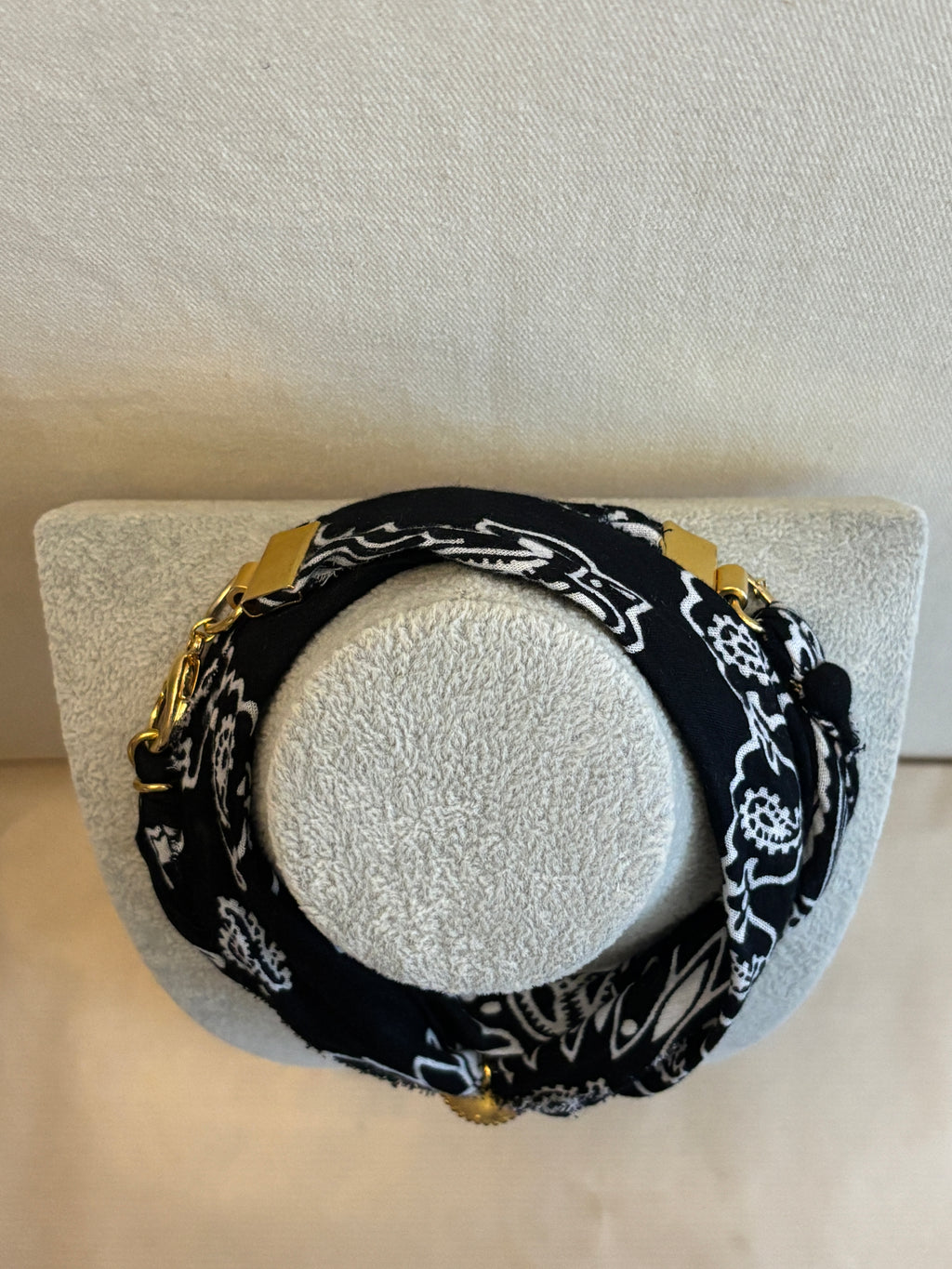 Black and white patterned headband on a gray stand with a blurred background