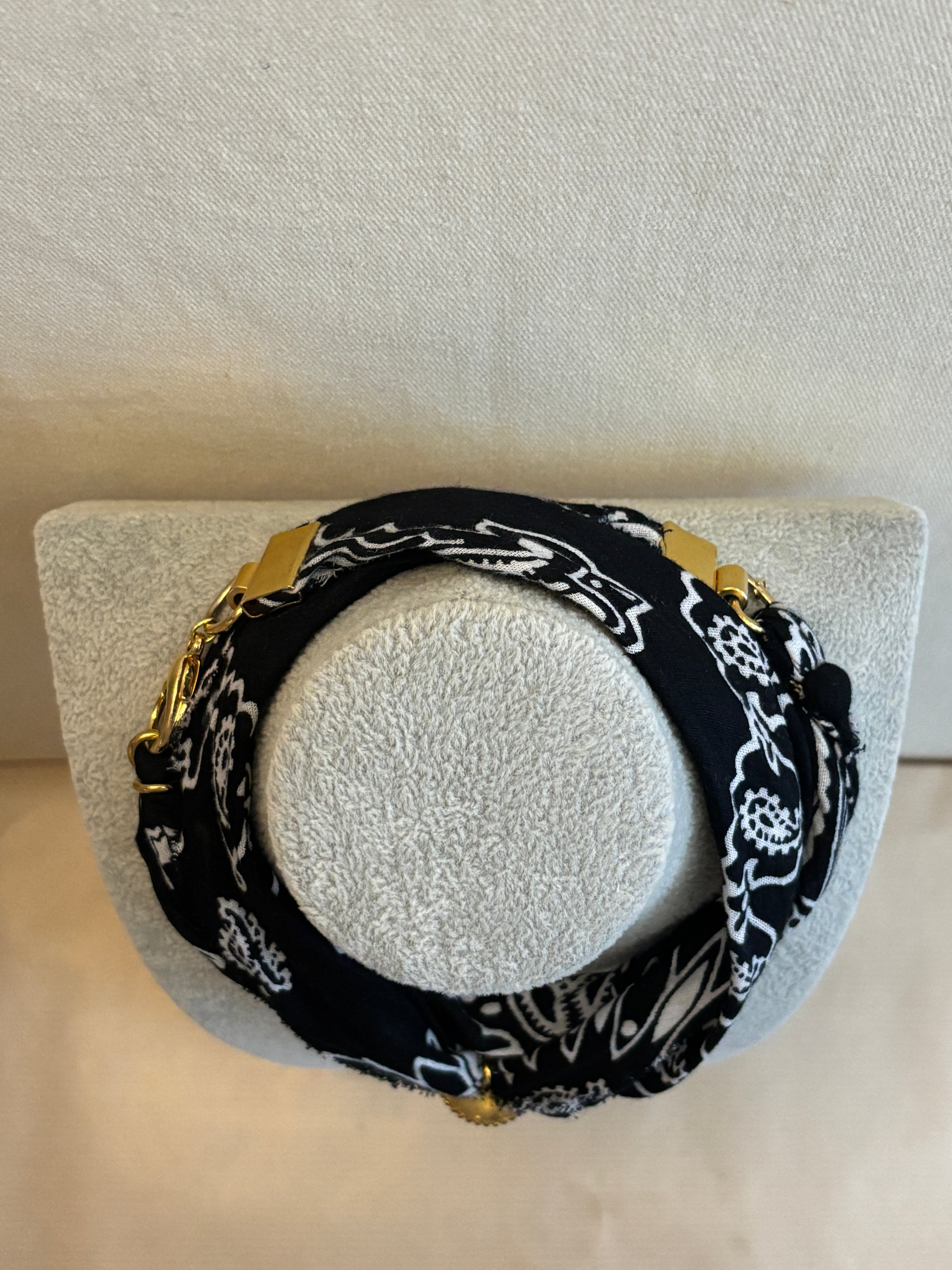 Black and white patterned headband on a gray stand with a blurred background