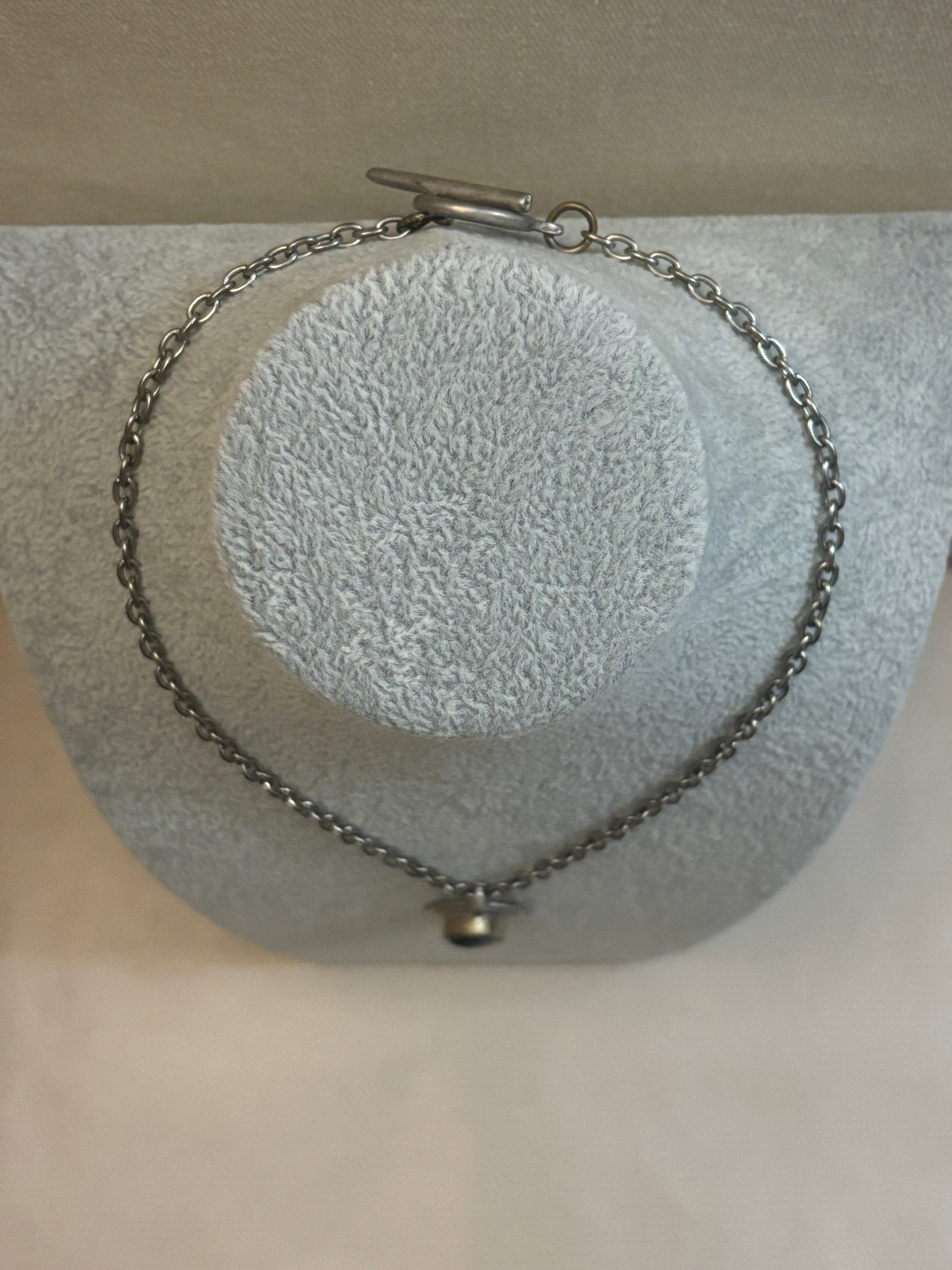 Silver chain bracelet on a textured gray surface