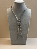 Necklace on a gray mannequin bust against a beige background