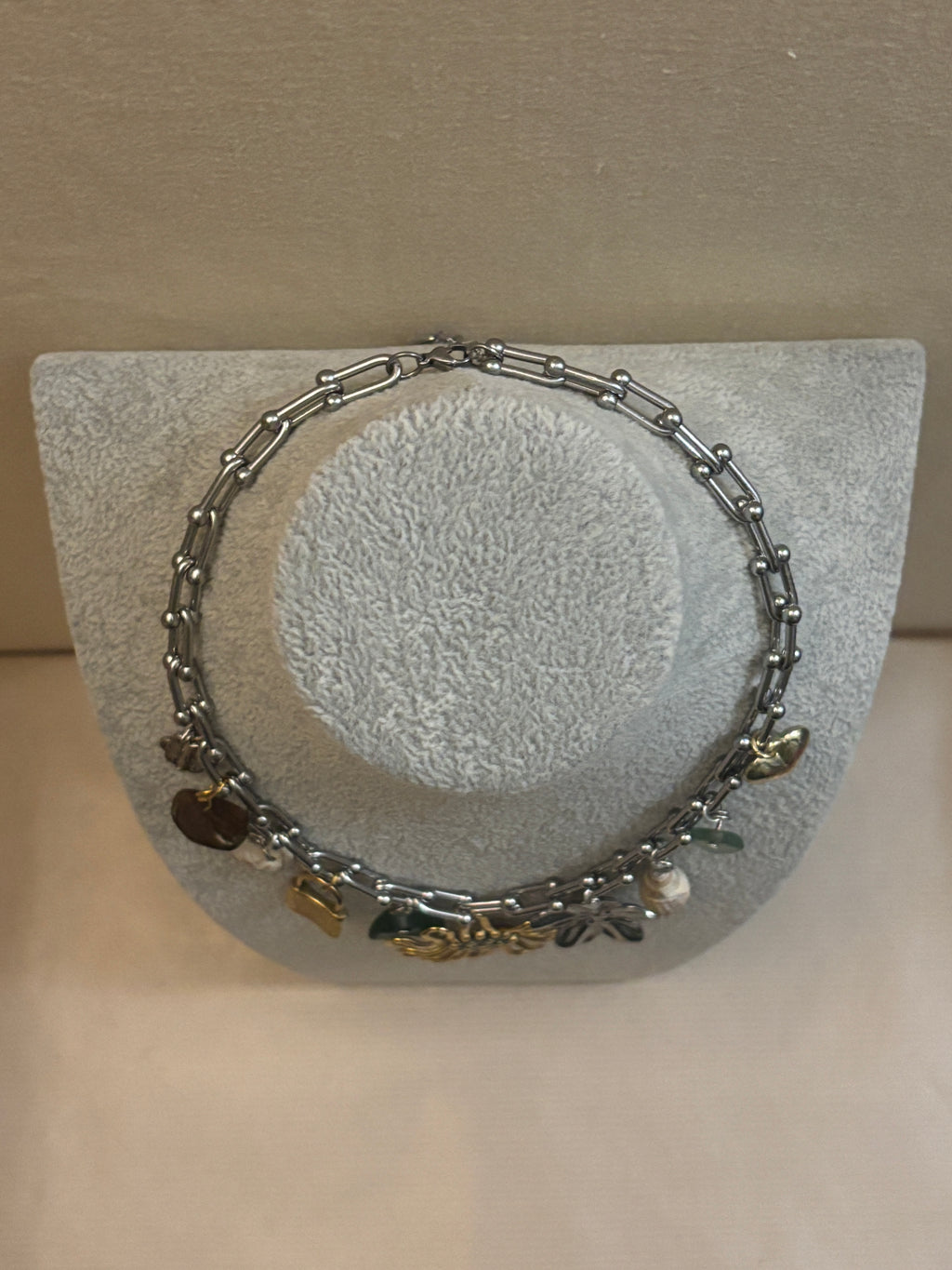 Silver bracelet with charms on a textured gray surface