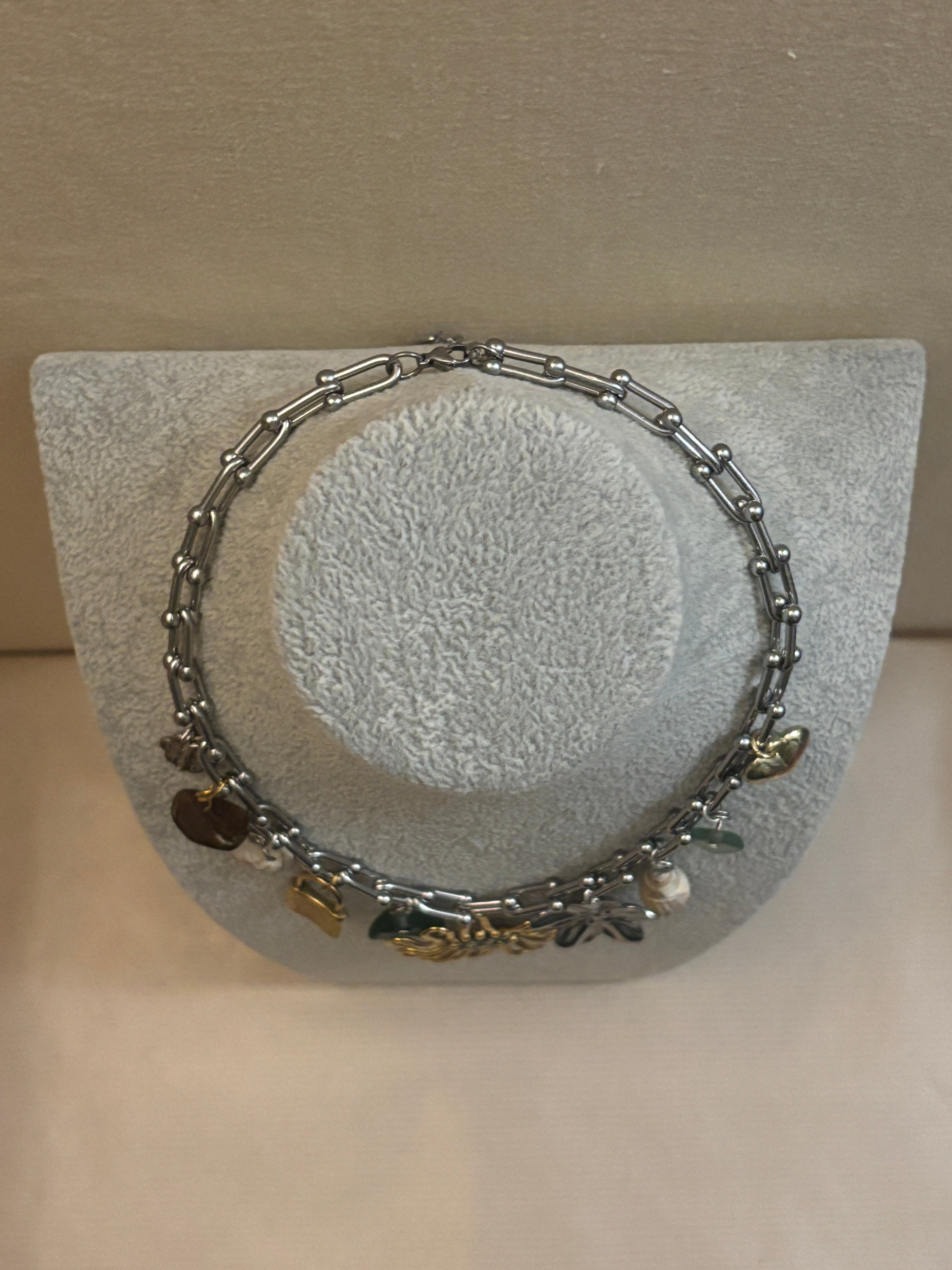Silver bracelet with charms on a textured gray surface