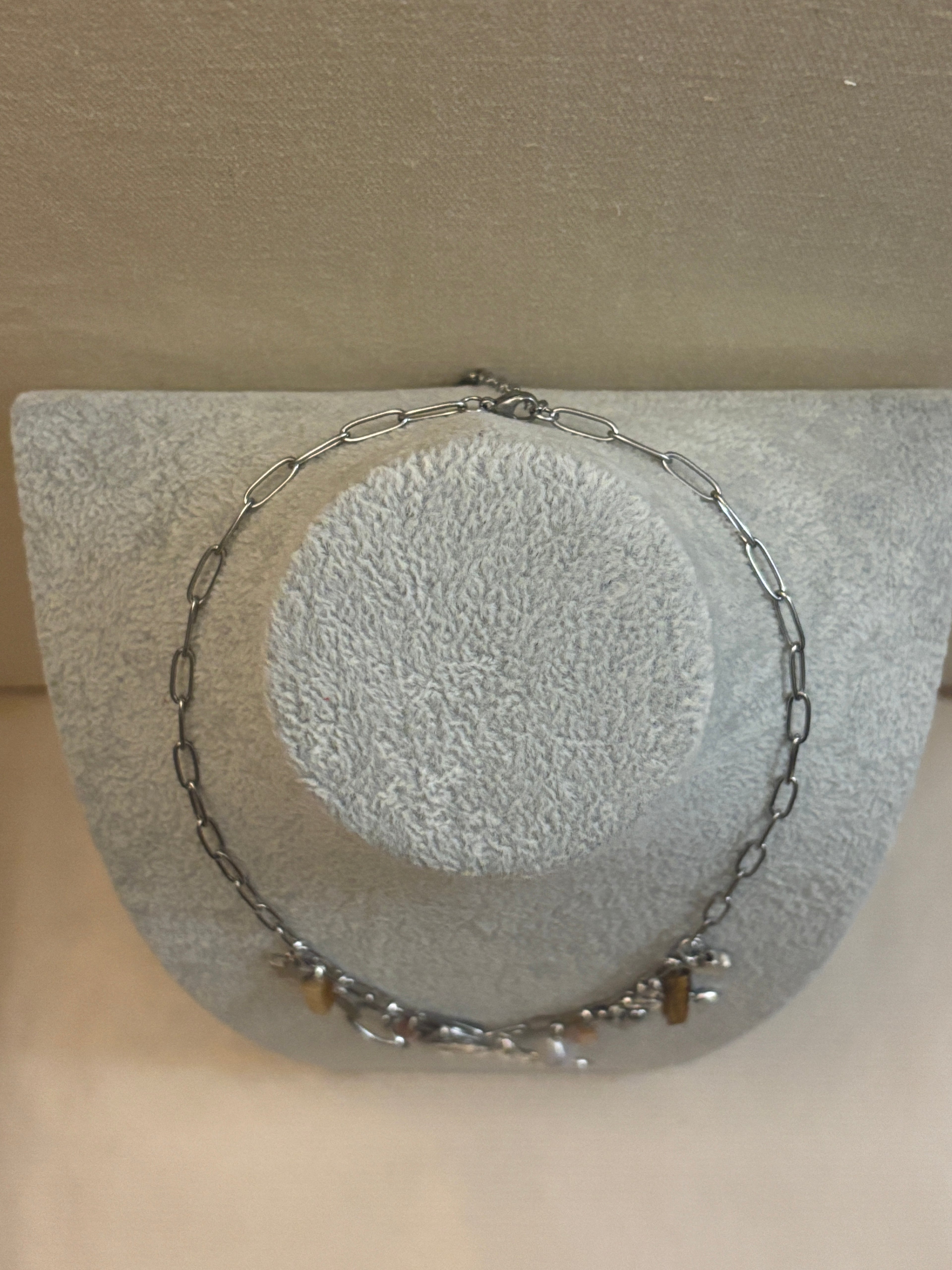 Silver chain necklace on a textured surface