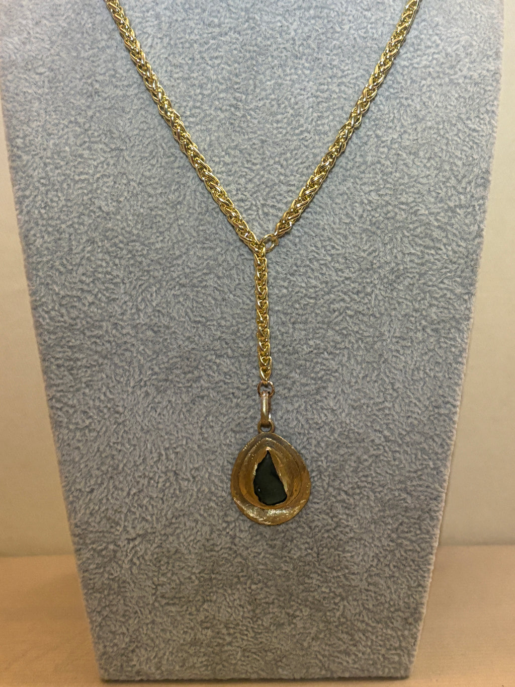 Gold chain necklace on a textured gray surface