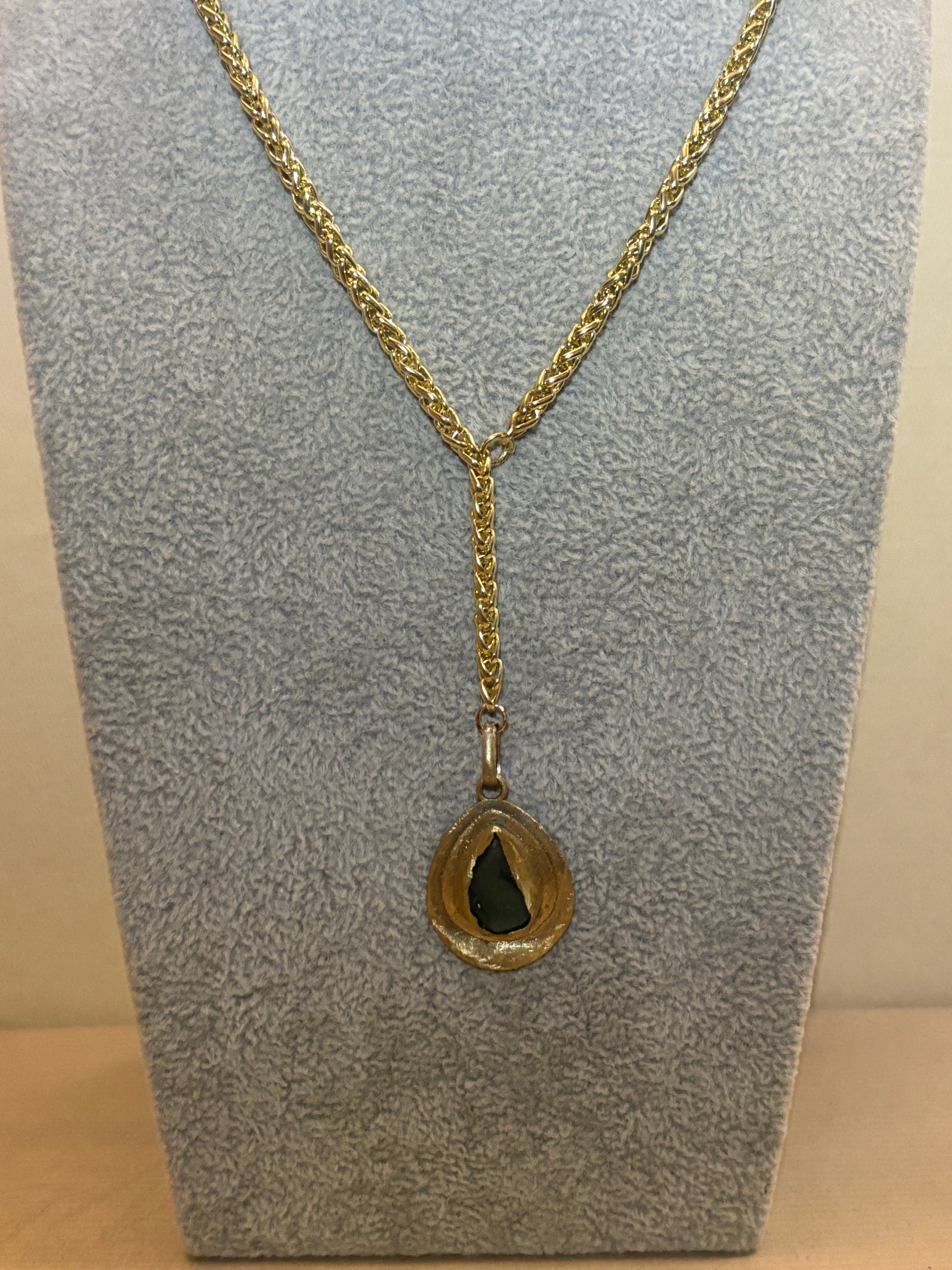 Gold chain necklace on a textured gray surface