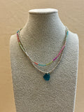 Necklace with a blue pendant on a mannequin bust against a beige background