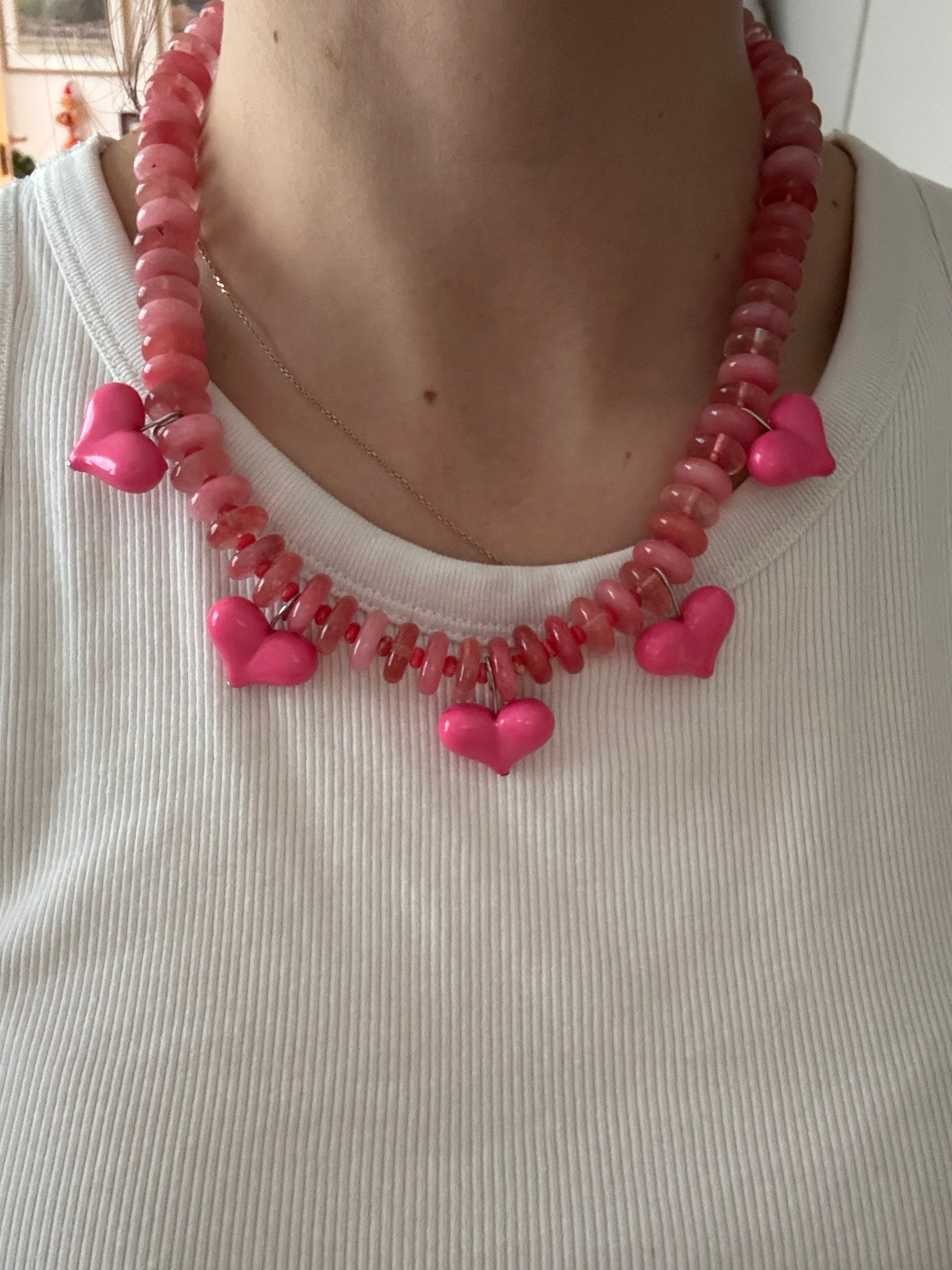 Necklace with pink heart-shaped beads on a textured surface