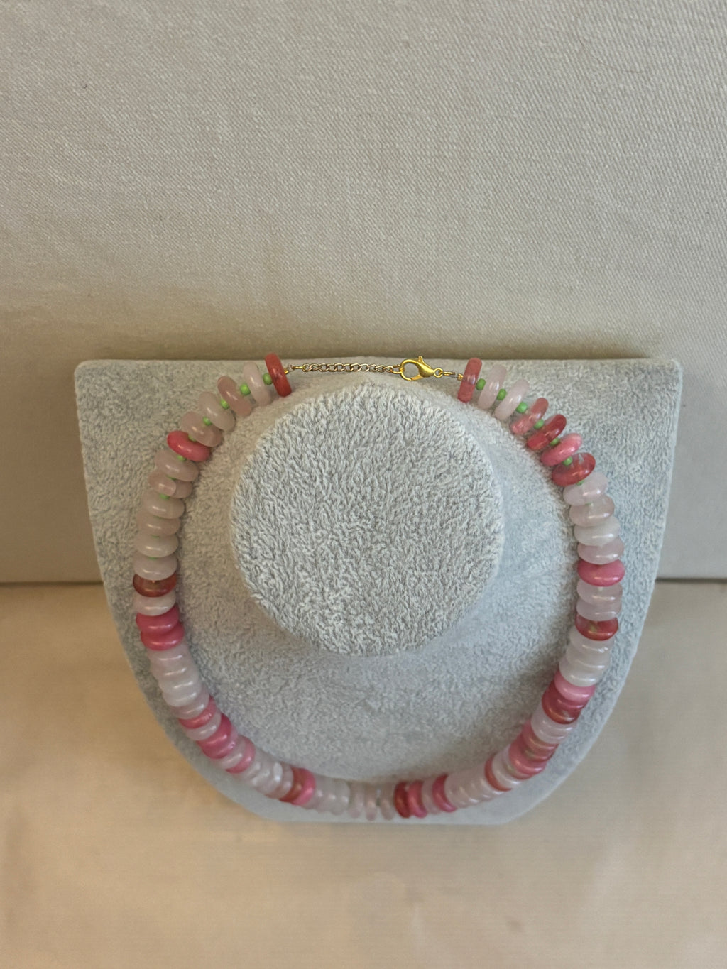 Beaded necklace on a textured display with a neutral background