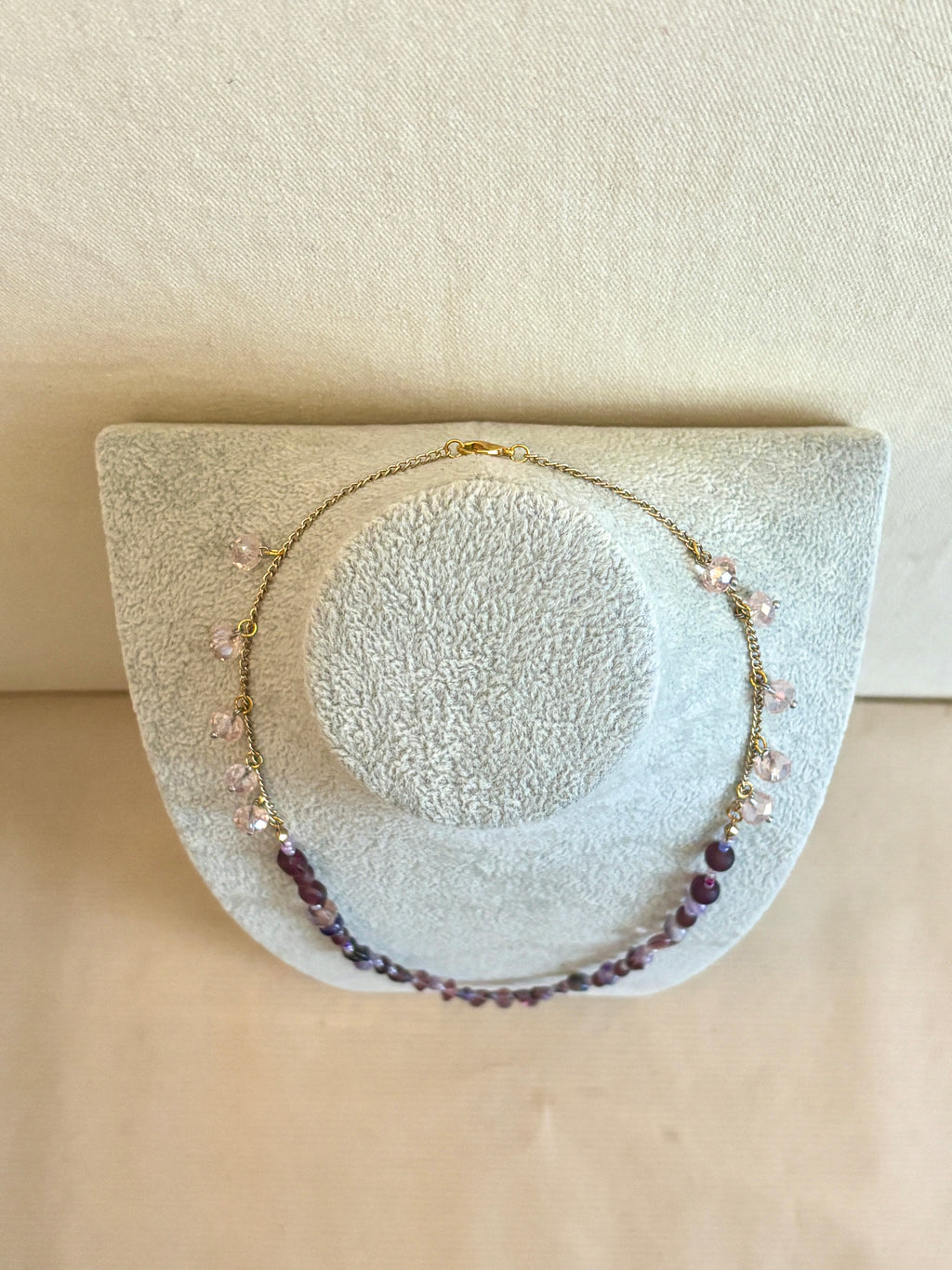 Necklace with beads on a textured white stand