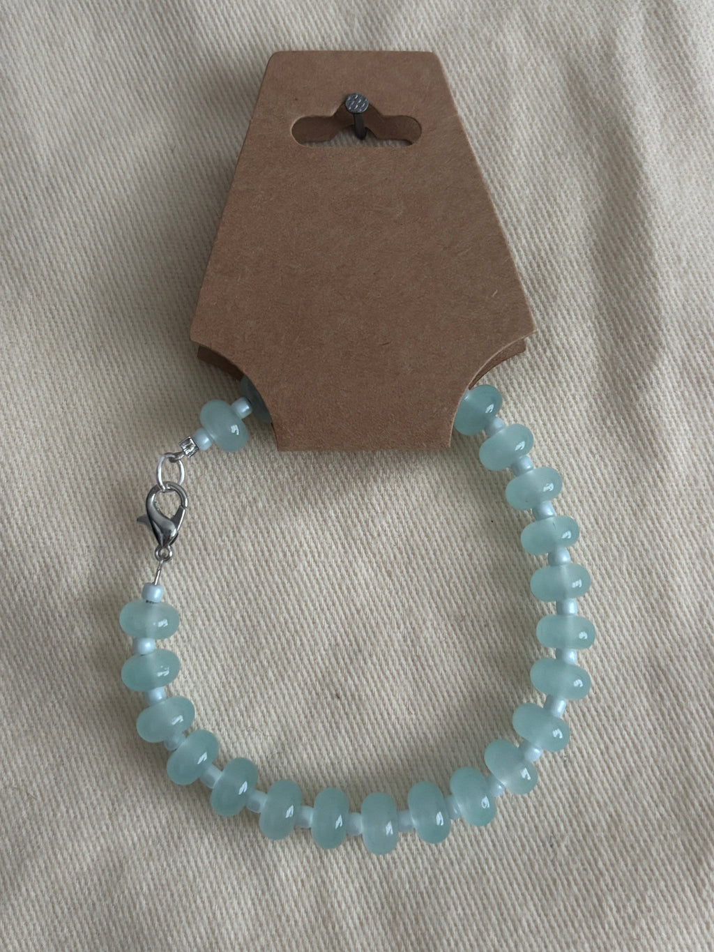 Blue beaded bracelet on a gray fabric background