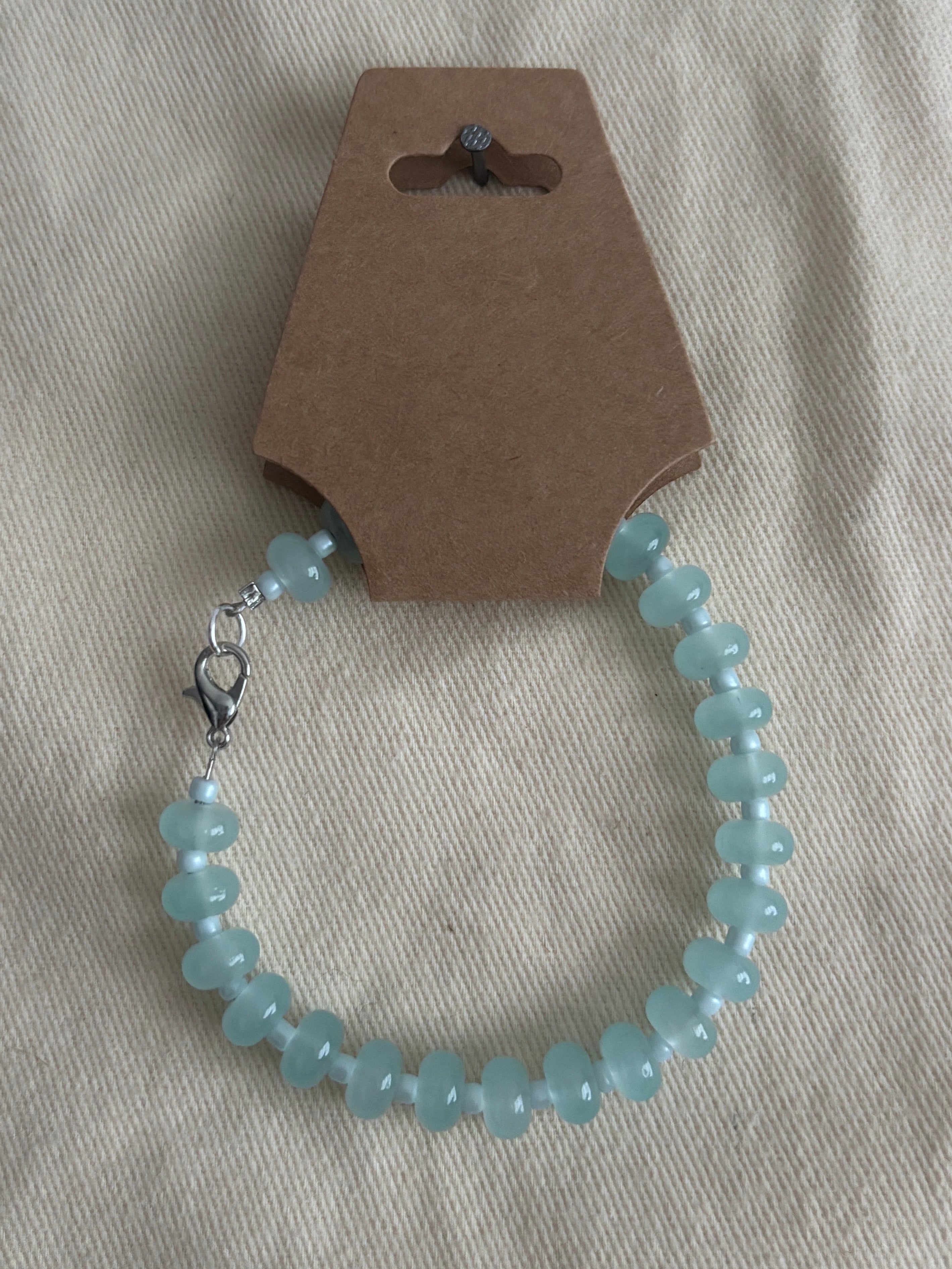 Blue beaded bracelet on a gray fabric background