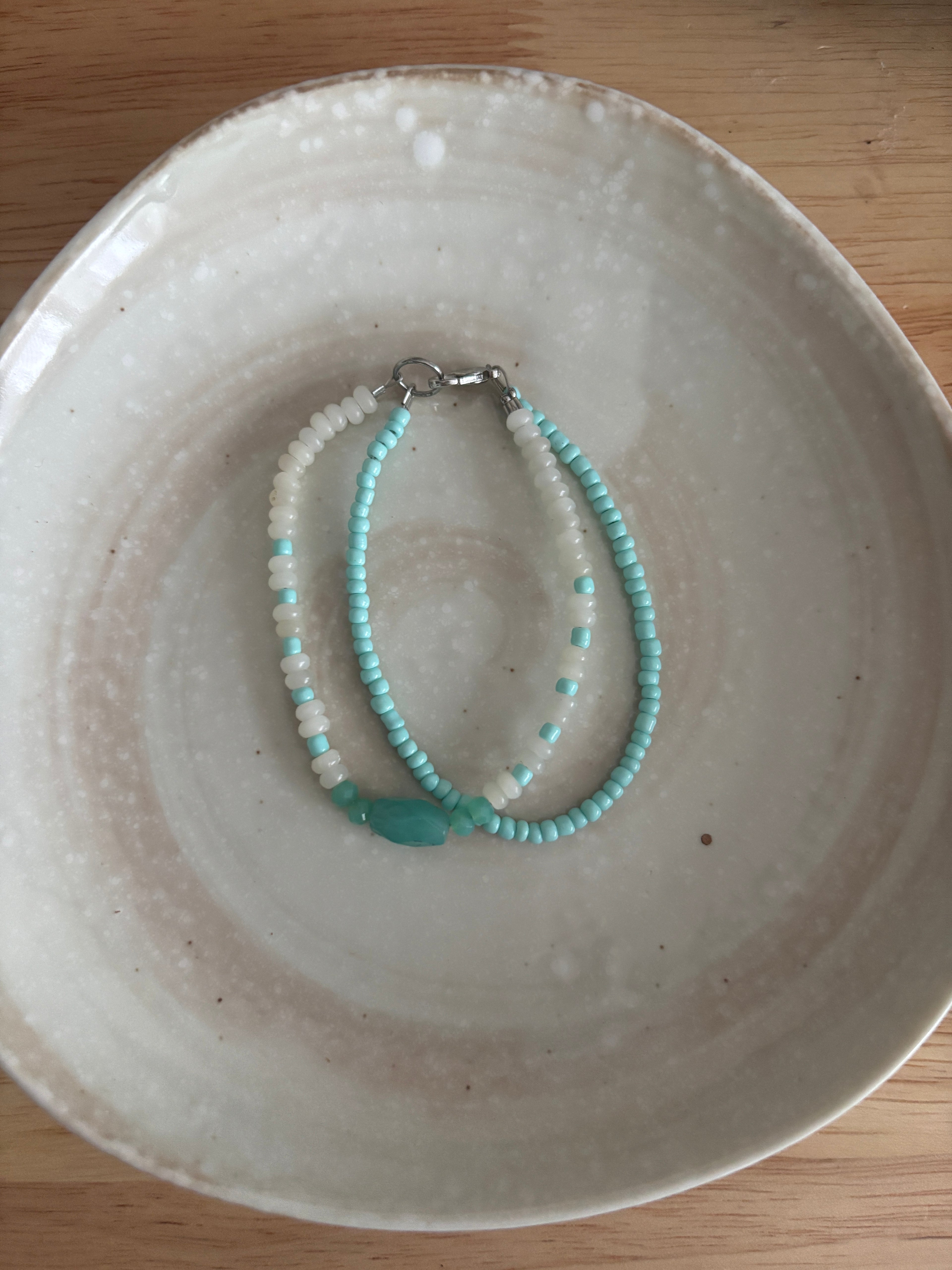 Beaded necklace on a textured ceramic plate