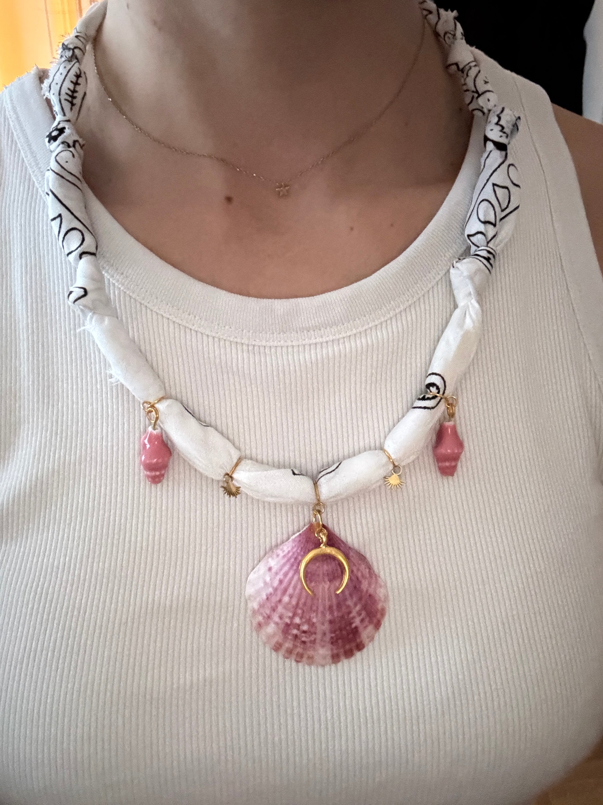 Necklace with shell and moon pendant on a white tank top
