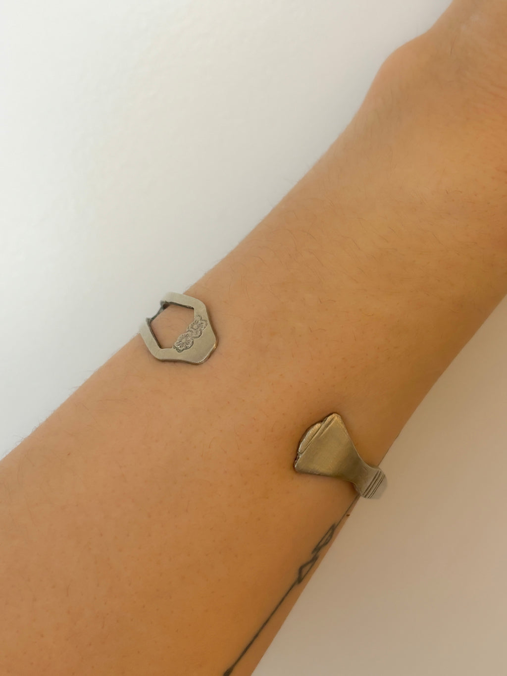metallic bracelets on a wrist against a white background