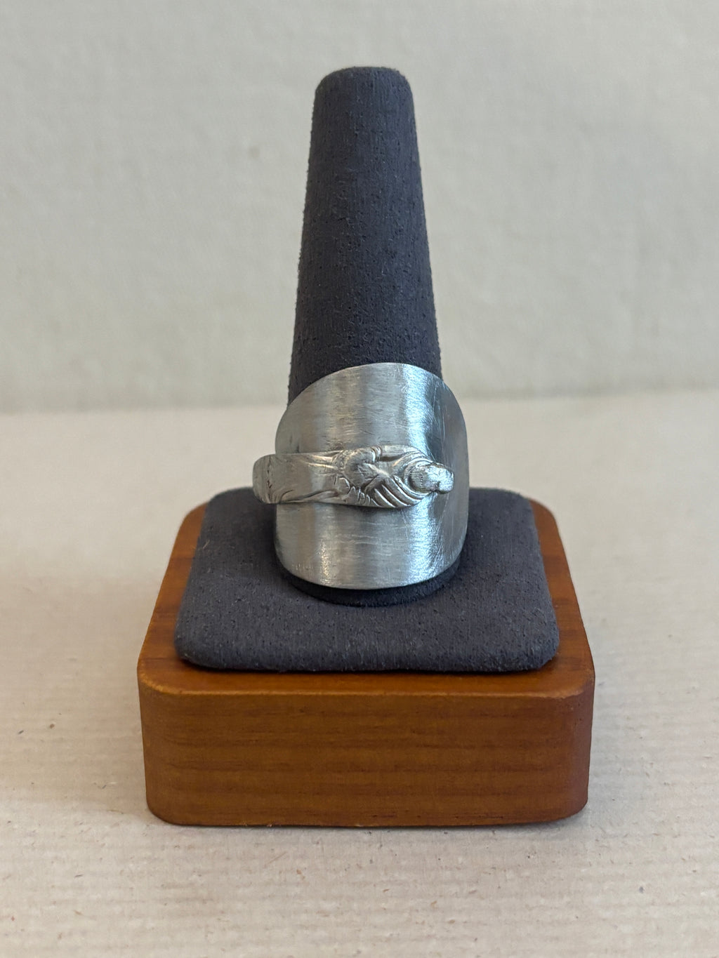 Decorative ring with wooden base, on a plain background