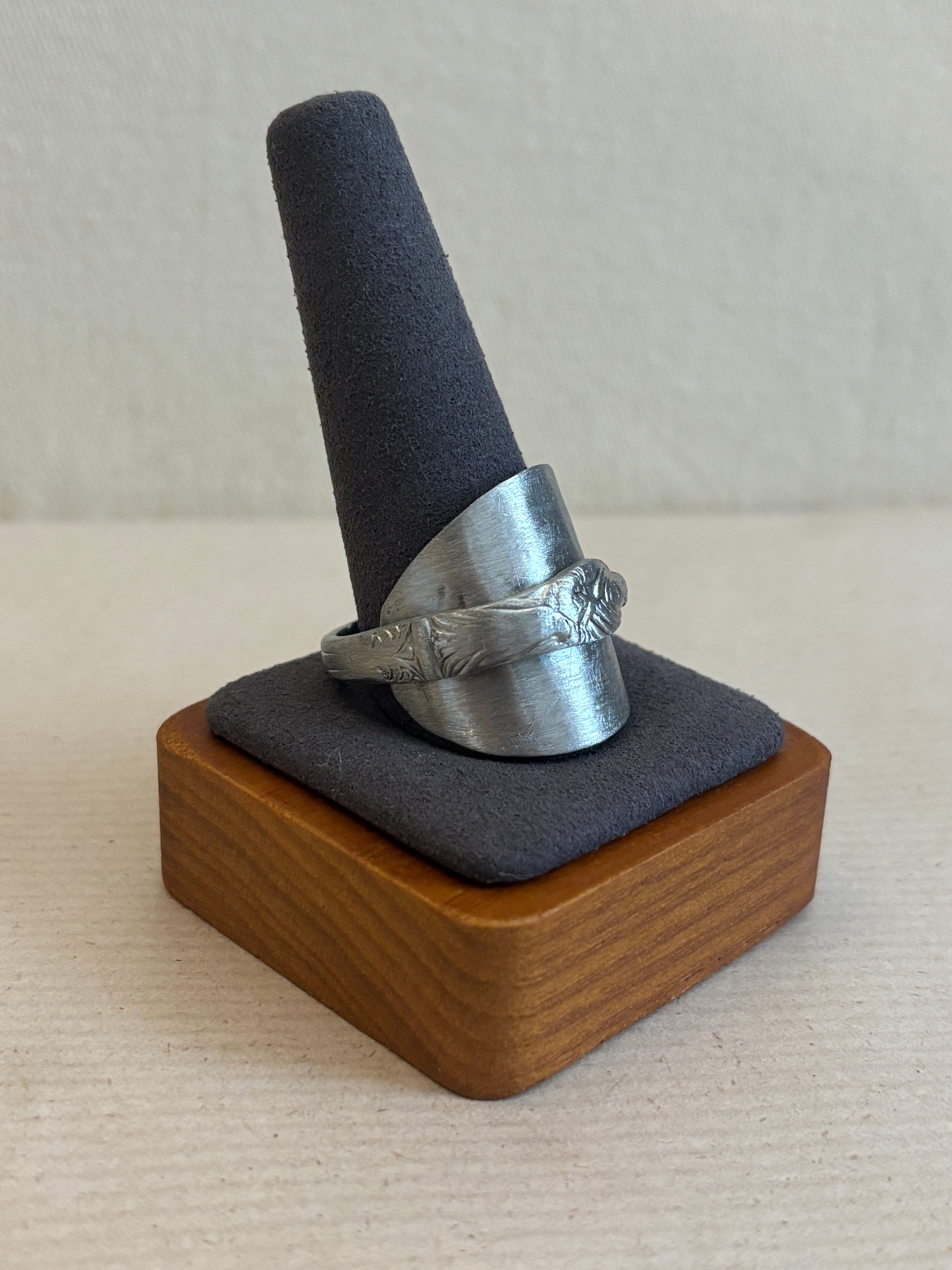 silver ring on a jewelry display with a plain background