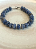 Blue beaded bracelet on a textured white surface