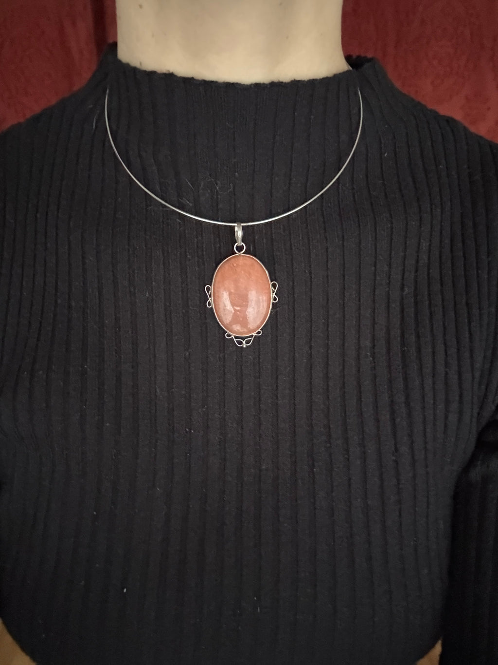Necklace with a pink stone pendant on a black shirt