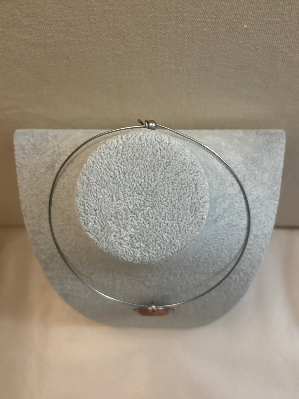 Round necklace on a textured gray surface